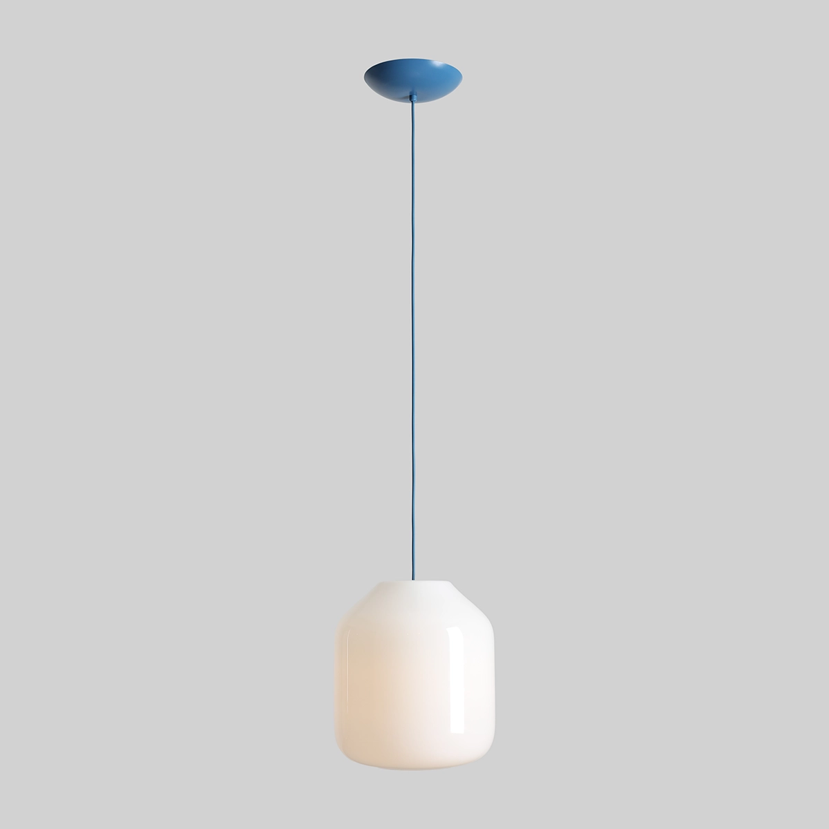 Lampa wisząca Flask Sapphire D27 z jednym gniazdem E27, w kolorze białym z niebieskim stelażem. Owalny klosz o gładkiej powierzchni, zawieszony na cienkim, niebieskim przewodzie, umieszczony na jasnoszarym tle.