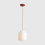 Lampa wisząca Flask Terra D27 z białym, szklanym kloszem w kształcie sześcianu i ceglastym, matowym mocowaniem. Zawieszona na długim, elastycznym przewodzie, idealna do nowoczesnych wnętrz.