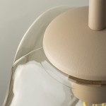 Lava Sabia D25 lampa wisząca w kolorze beżowym z oprawą E27. Ujęcie z góry, pokazujące gładką, okrągłą podstawę oraz przezroczystą klosz w kształcie fali, z widocznymi detalami wykończenia.