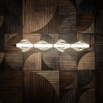 Lampa wisząca LED Elva 30W, ciepła barwa 3000K, mosiężna konstrukcja z bursztynowymi kloszami. Ujęcie z góry, zamontowana na tle drewnianych paneli o różnych fakturach. Klosze mają falisty kształt, rozpraszając światło.