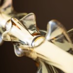 Lampa wisząca LED Elva 30W, w kolorze mosiądzu i bursztynu, z detalami w kształcie falistych elementów. Ujęcie z bliska ukazuje fakturę oraz połysk materiału, podkreślając elegancki design i nowoczesny styl oświetlenia.