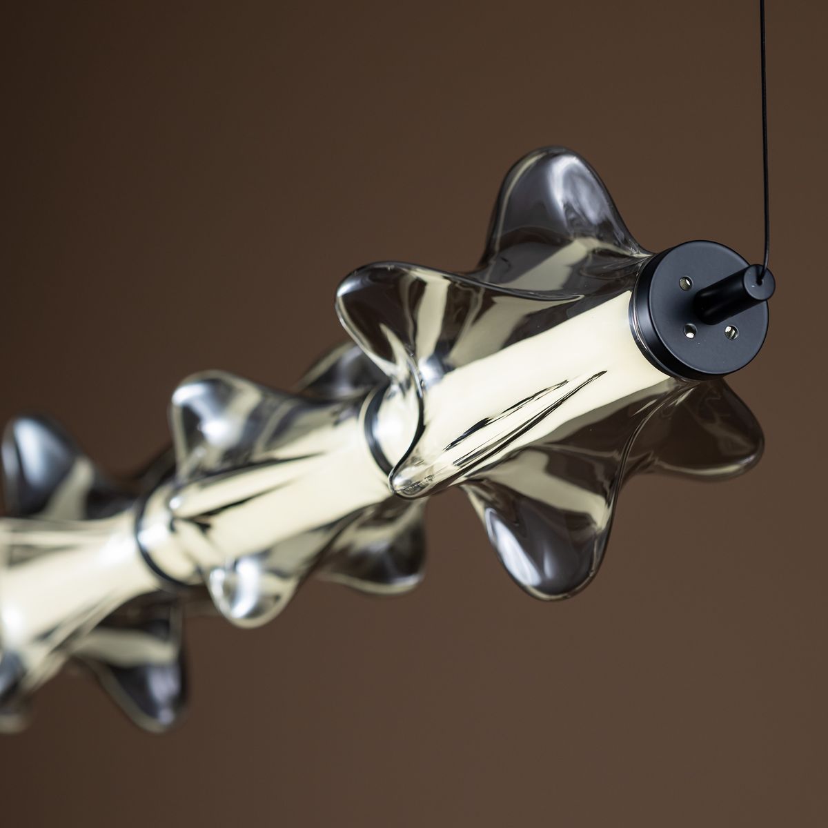 Lampa wisząca LED Elva 30W 3000K w kolorze czarnym/grafitowym, o nowoczesnym designie z przezroczystymi, falistymi kloszami. Ujęcie z boku, ukazujące detale mocowania i kształt lampy. Idealna do nowoczesnych wnętrz.