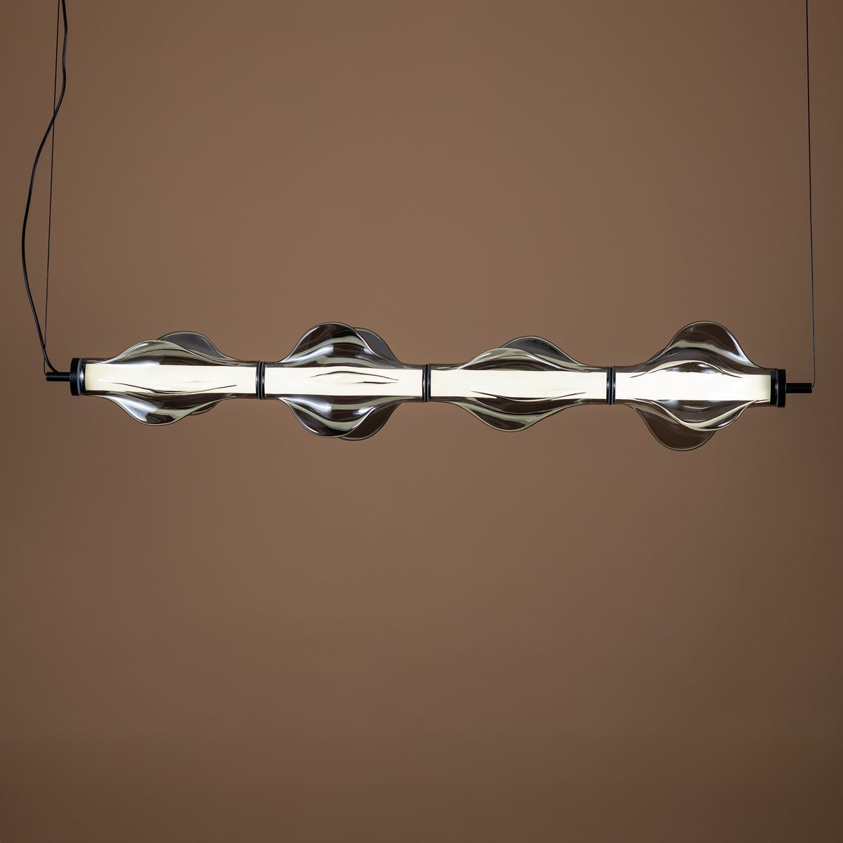 Lampa wisząca LED Elva 30W w kolorze czarnym i grafitowym, o nowoczesnym designie. Posiada sześć falistych elementów, które osłaniają źródło światła. Zawieszona na cienkim przewodzie, idealna do aranżacji wnętrz.