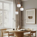 Lampa wisząca Ballo 3xE14 w beżowym kolorze, z trzema okrągłymi kloszami z białego szkła i drewnianymi detalami. Ujęcie z góry, w kontekście nowoczesnego wnętrza z okrągłym drewnianym stołem i jasnymi zasłonami.