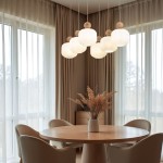 Lampa wisząca Ballo w kolorze beżowym, z sześcioma kloszami E14, zawieszona nad okrągłym drewnianym stołem. Klosze mają zaokrąglony kształt z żłobioną fakturą i drewnianymi elementami. W tle zasłony i bukiet suszonych kwiatów.