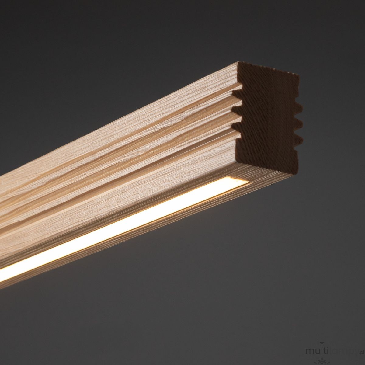 Czarna lampa sufitowa LED Viga Wood o mocy 14W i barwie 3000K, z elementem w kolorze sosny. Widoczny detal z gładkiego drewna z wypustkami, wzdłuż którego znajduje się wąski pasek światła. Produkt prezentowany w zbliżeniu, na ciemnym tle.