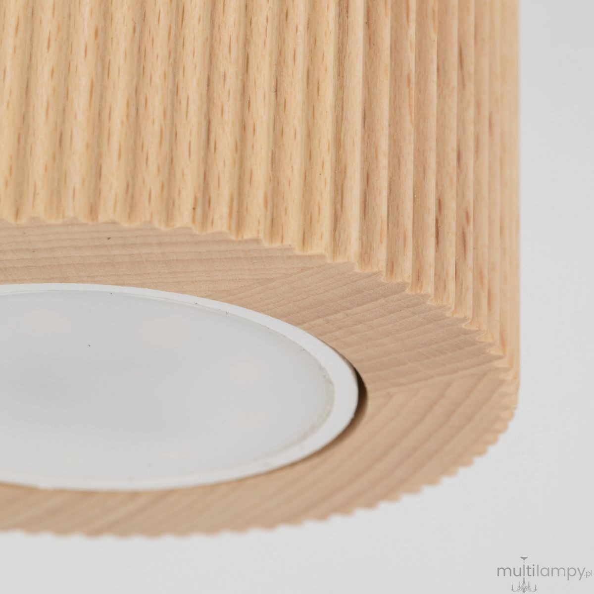 Lampa sufitowa Eve Corte 1xGU10 w kolorze naturalnego buku, z wyraźnym żłobieniem na obudowie. Okrągłe, mleczne szkło osłania źródło światła, w całości widoczna z bliska, zmontowana, z delikatnym, teksturowanym wykończeniem.