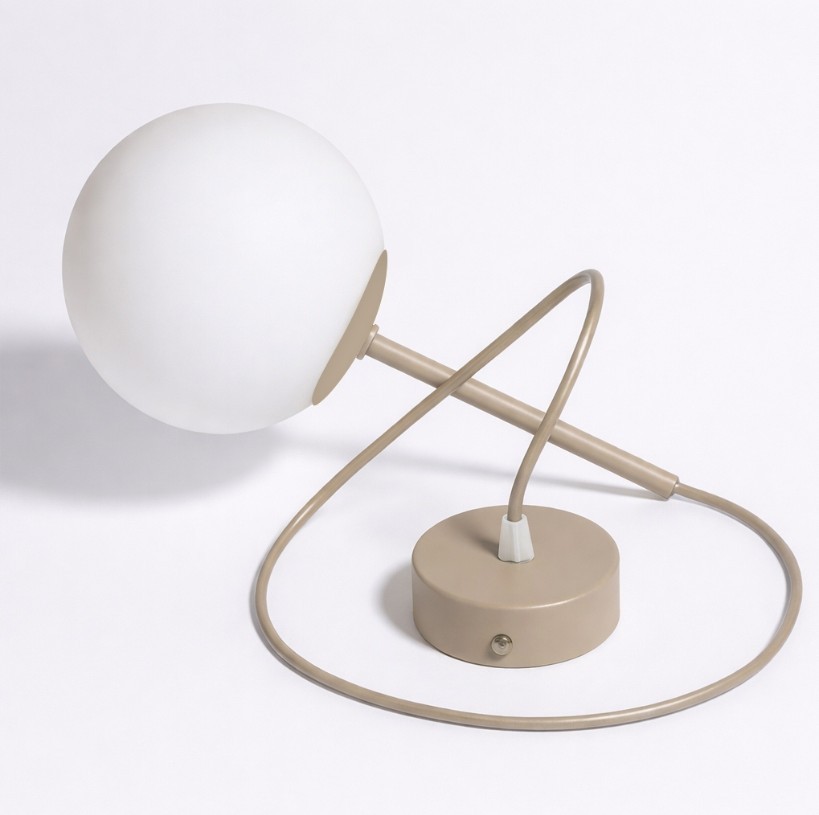 Beżowa lampa wisząca Sphere z kulistym, matowym kloszem na metalowym ramieniu. Ujęcie z boku, ukazujące okrągłą podstawę oraz przewód. Prosta, nowoczesna forma, idealna do aranżacji wnętrz.