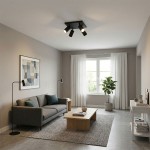 Lampa sufitowa Spoti SQ z czarnym wykończeniem, wyposażona w cztery ruchome reflektory GU10. Zawieszona na suficie w przestronnej, nowoczesnej aranżacji salonu z szarym kanapą, drewnianym stolikiem i rośliną w doniczce.