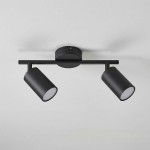 Lampa sufitowa Stico z dwoma reflektorami na ruchomej belce, wykonana w czarnym metalu. Reflektory mają cylindryczny kształt z białymi kloszami. Montowana na suficie, idealna do oświetlenia wnętrz.