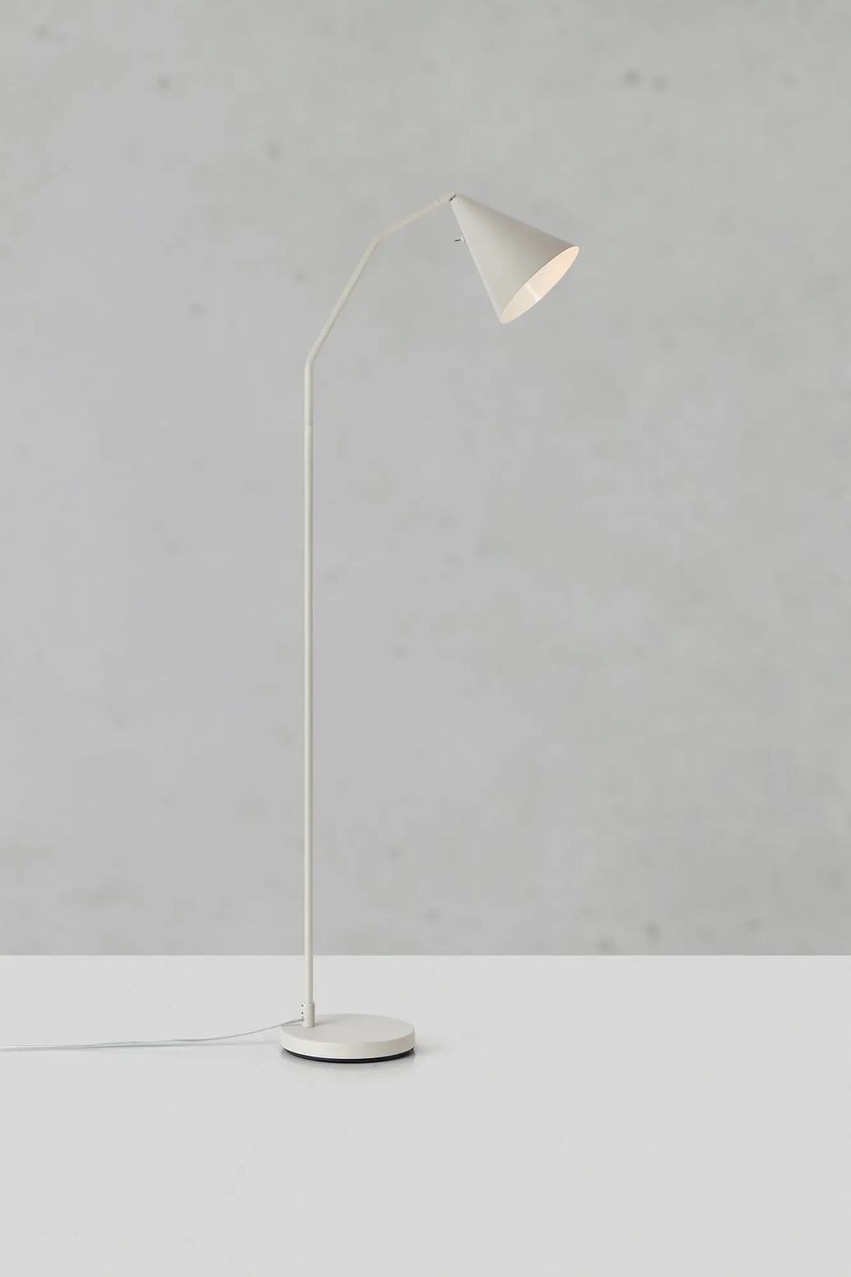 Lampa podłogowa LED Funil 4,9W w beżowym kolorze, z prostym, smukłym trzonkiem i stożkowym kloszem. Ujęcie frontalne, stojąca na okrągłej podstawie. Tło w odcieniach szarości, minimalistyczne.