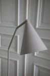 Lampa podłogowa LED Funil 4,9W w kolorze beżowym, z konicznym kloszem. Ujęcie z boku, pokazujące smukły, zakrzywiony stelaż i detal mocowania klosza. Tło w jasnym kolorze, podkreślające minimalistyczny design lampy.