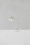 Lampa stołowa Tilt E27 w szarym kolorze z metalowym kloszem i elastycznym ramieniem. Ustawiona na okrągłej podstawie, skierowana w górę. Tło w jasnym odcieniu, podkreślającym prosty design. Idealna do biura lub na stół.