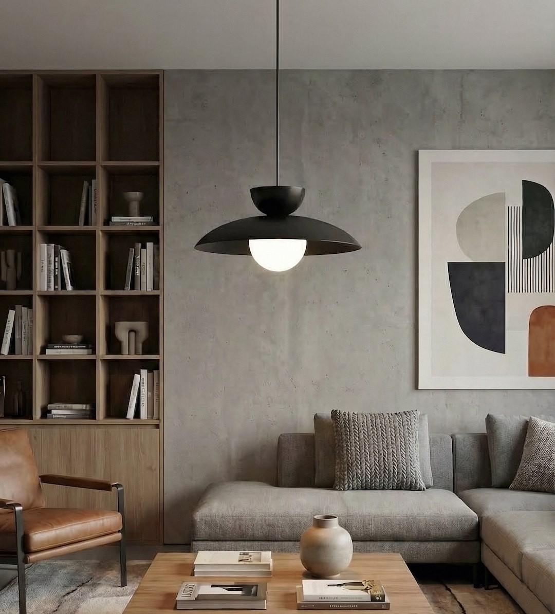 Lampa wisząca Mulan w kolorze czarnym, z jedną żarówką G9. Okrągła, matowa oprawa z białym kloszem, zawieszona na cienkim kablu. W tle nowoczesny salon z regałem, sofą i stolikiem kawowym.