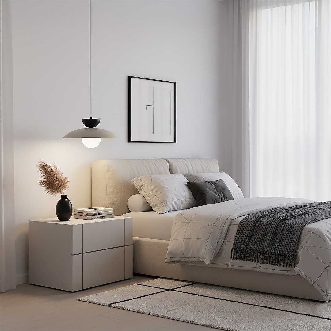 Lampa wisząca Mulan w kolorze mokka i czarnym, zawieszona nad łóżkiem w sypialni. Okrągła, biała klosz z czarnym detalem, wisząca na cienkim przewodzie. W tle jasne ściany, zasłony, miękkie poduszki i stół nocny z dekoracją.