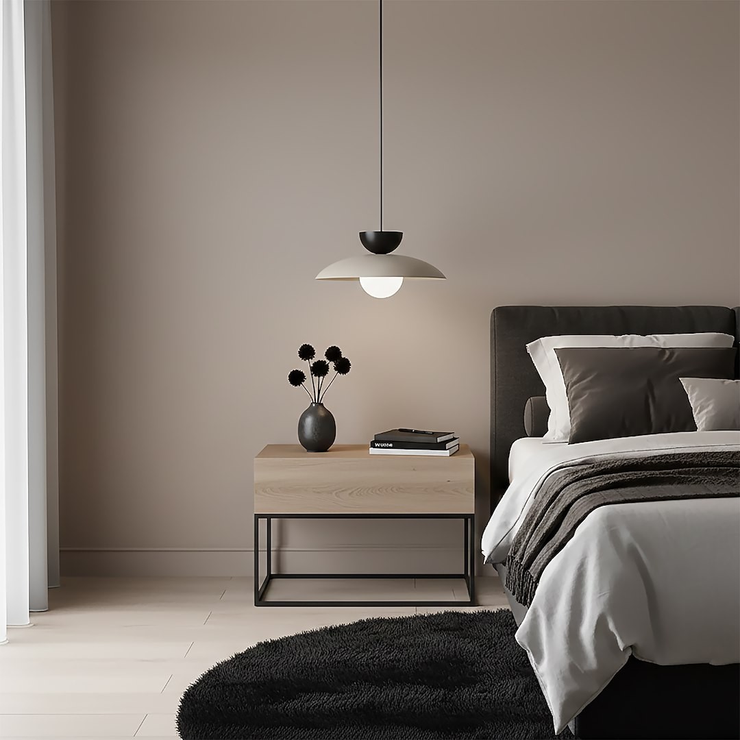 Lampa wisząca Mulan w kolorze mokka i czarnym, z jednym źródłem światła G9, zawieszona nad drewnianą szafką nocną. Oświetlenie tworzy przytulny klimat w sypialni, obok czarna waza z dekoracyjnymi roślinami i książki na stoliku.
