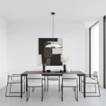 Lampa wisząca Babel 1xGX53 w kolorze czarnym i białym, zawieszona nad stołem w minimalistycznej jadalni. W tle czarno-biała grafika, jasne ściany oraz drewniany stół z białymi krzesłami.
