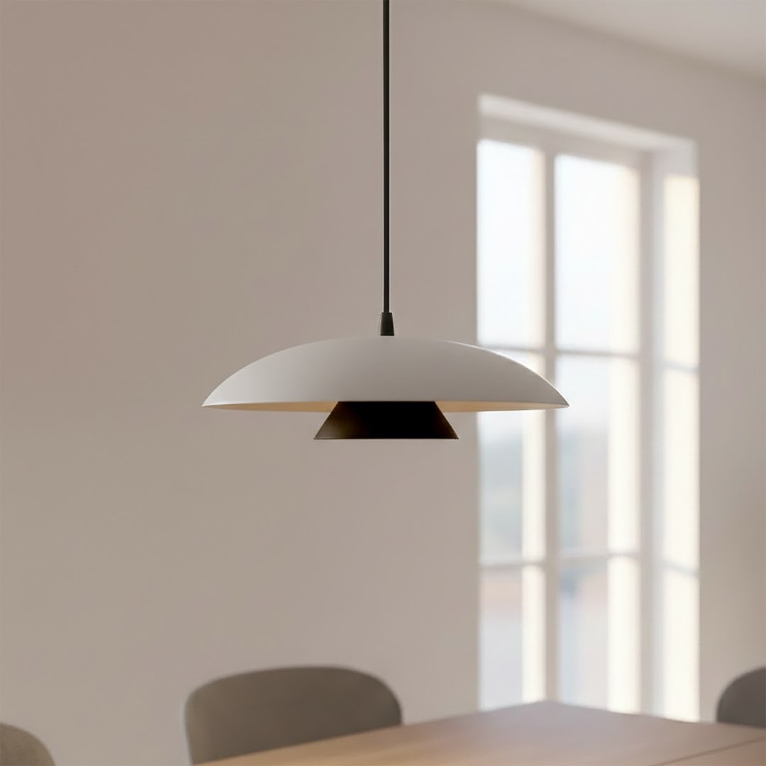 Lampa wisząca Babel 1xGX53 w kolorze czarnym i białym, z okrągłym kloszem oraz trójkątnym detalem, zawieszona na cienkim, czarnym przewodzie. Produkt wisi nad drewnianym stołem w jasnym wnętrzu, w tle okna.