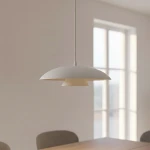 Lampa wisząca w odcieniu białym z dwoma warstwami klosza: górna, okrągła część jest matowa, a dolna to stożkowata, subtelnie odbijająca światło. Zawieszona na długim, cienkim przewodzie, w jasnym wnętrzu z dużymi oknami.