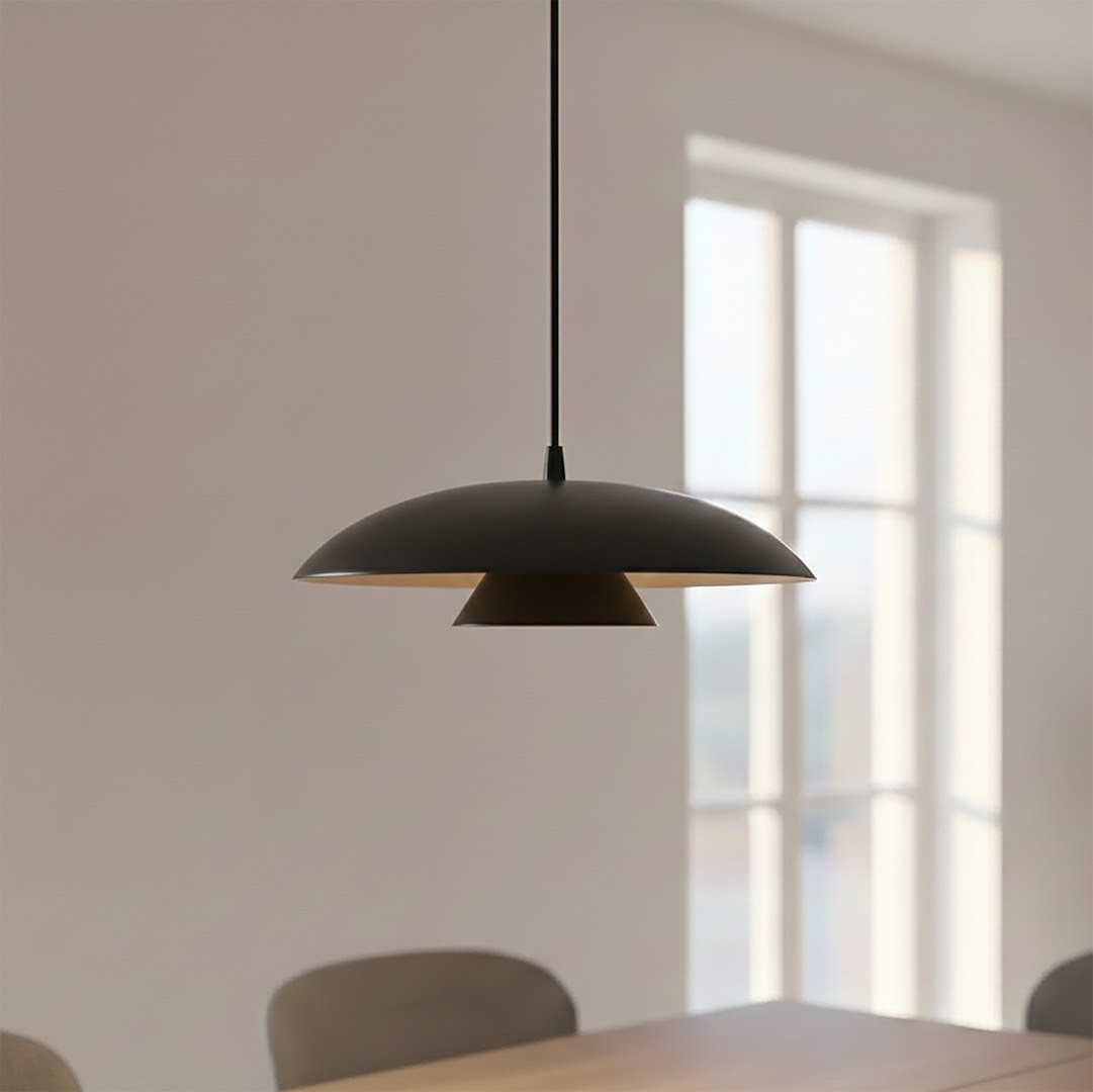 Czarna lampa wisząca Babel 1xGX53 z okrągłym kloszem, zawieszona na cienkim przewodzie. Wnętrze klosza ma jasny kolor, co kontrastuje z zewnętrzną powierzchnią. Lampa umieszczona w jasnym pomieszczeniu z oknami w tle.