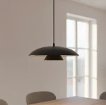 Czarna lampa wisząca Babel 1xGX53 z okrągłym kloszem, zawieszona na cienkim przewodzie. Wnętrze klosza ma jasny kolor, co kontrastuje z zewnętrzną powierzchnią. Lampa umieszczona w jasnym pomieszczeniu z oknami w tle.
