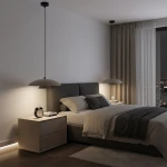 Lampa wisząca Babel 1xGX53 w kolorze czarnym i mokka, zawieszona nad łóżkiem w sypialni, z minimalistycznym kloszem. W otoczeniu jasne meble, poduszki i zegar na stoliku nocnym, z zasłonami w odcieniach beżu.