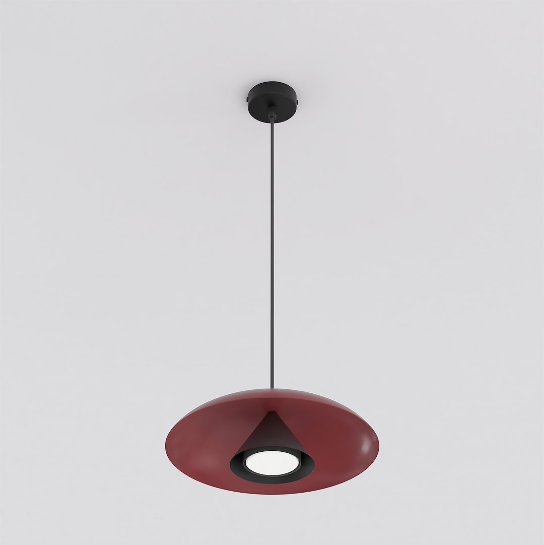 Lampa wisząca Babel w kolorze czarnym i burgundowym, o kształcie stożkowym, zawieszona na cienkim przewodzie. Posiada okrągły klosz z wbudowanym źródłem światła GX53. Tło białe, co podkreśla intensywność kolorów.