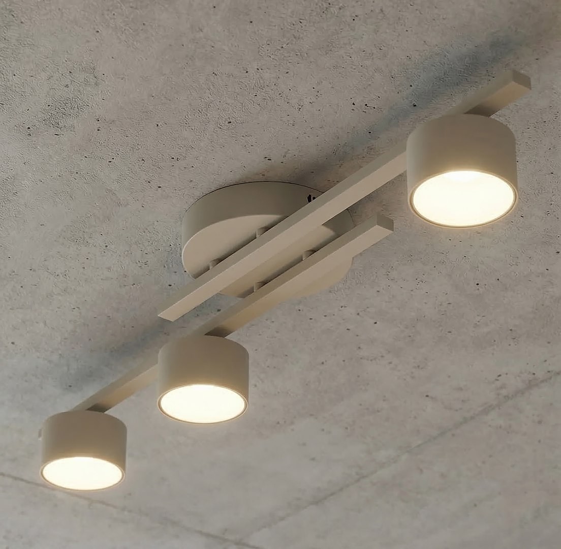 Fragment lampy sufitowej 3xGX53 w kolorze mokka, z trzema cylindrycznymi kloszami zamocowanymi na prostokątnej podstawie. Ujęcie z dołu, ukazujące detale konstrukcji i rozkład światła.