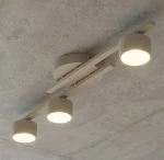 Fragment lampy sufitowej 3xGX53 w kolorze mokka, z trzema cylindrycznymi kloszami zamocowanymi na prostokątnej podstawie. Ujęcie z dołu, ukazujące detale konstrukcji i rozkład światła.