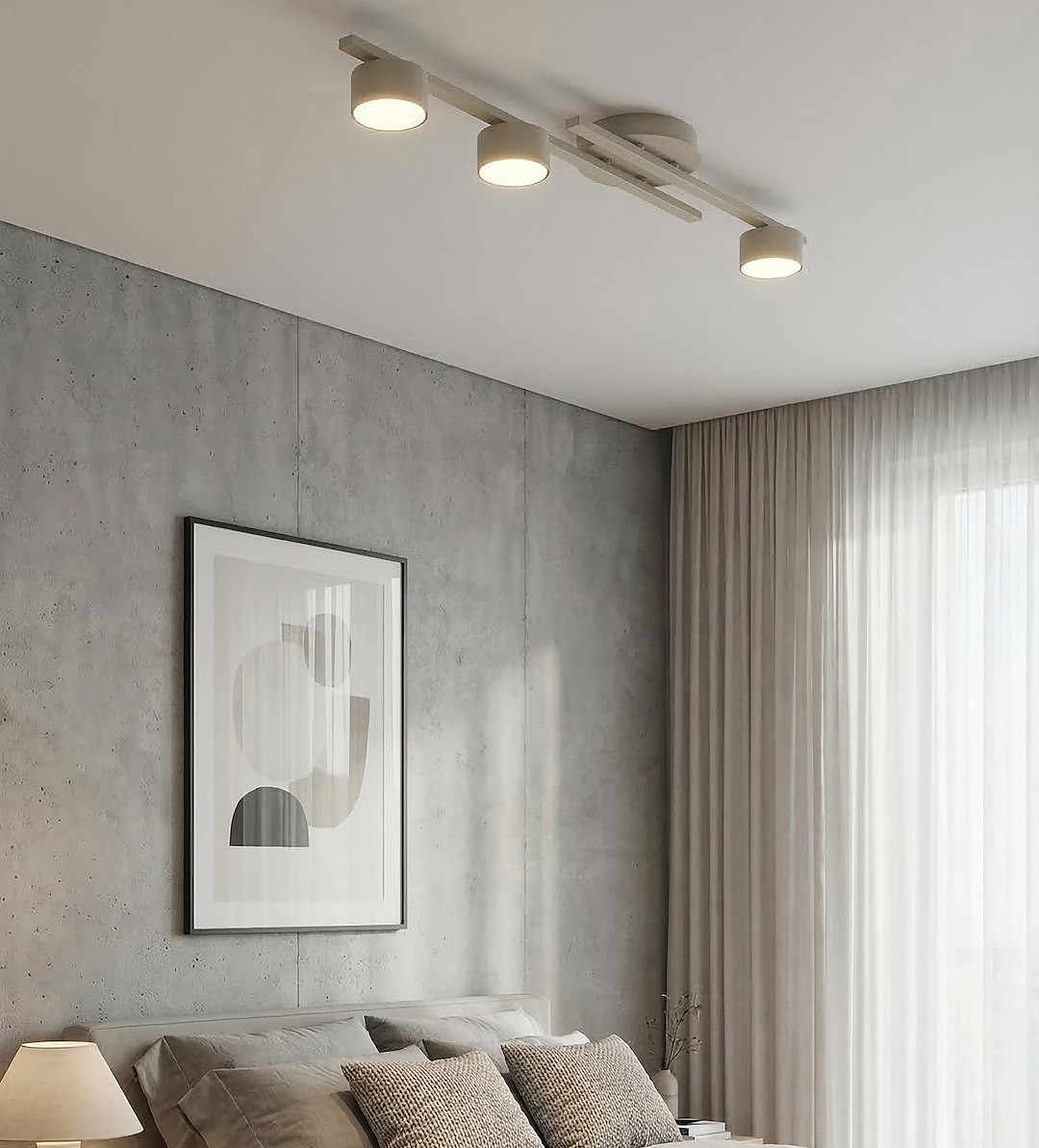 Fragment lampy sufitowej 3xGX53 w kolorze mokka, zamontowanej na suficie. Składa się z trzech okrągłych źródeł światła, skierowanych w dół, umieszczonych na poziomej listwie. W tle widoczna sypialnia z szarymi ścianami i jasnymi zasłonami.