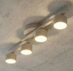Lampa sufitowa 4xGX53 w kolorze mokka, składająca się z czterech okrągłych kloszy na prostokątnej podstawie, zamontowana na suficie. Klosze emitują ciepłe światło, co tworzy przytulną atmosferę.