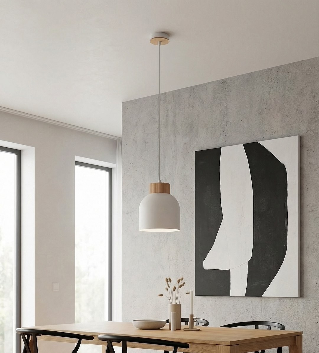 Lampa wisząca Vigo w kolorze białym z drewnianym detalem u góry, zawieszona na cienkim przewodzie. Produkt umieszczony w nowoczesnym wnętrzu z betonową ścianą i drewnianym stołem, w otoczeniu okien i dekoracji.