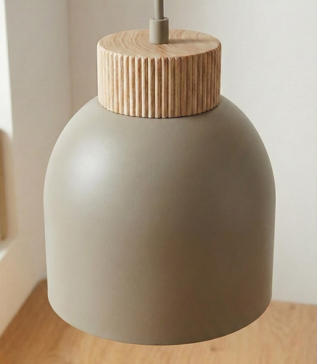 Lampa wisząca Vigo z kloszem w kolorze mokka, o zaokrąglonym kształcie, z drewnianym, żłobionym wykończeniem u góry. Zawieszona na cienkim przewodzie, idealna do nowoczesnych wnętrz.