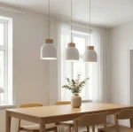 Lampa wisząca Vigo 3xE27 w białym kolorze z drewnianymi detalami, zawieszona nad drewnianym stołem. Widoczne trzy klosze w kształcie kubka, w tle okna i zasłony, dekoracja stołu z wazonem i roślinami.