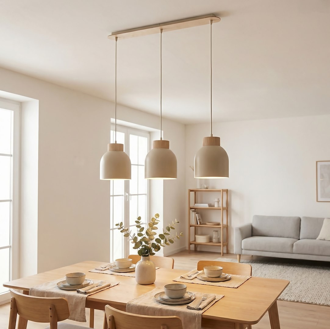 Lampa wisząca Vigo 3xE27 w kolorze mokka z trzema zaokrąglonymi kloszami. Zawieszona na prostokątnej podstawie, w otoczeniu stołu z nakryciem. Jasne tło i naturalne elementy dekoracyjne w aranżacji wnętrza.