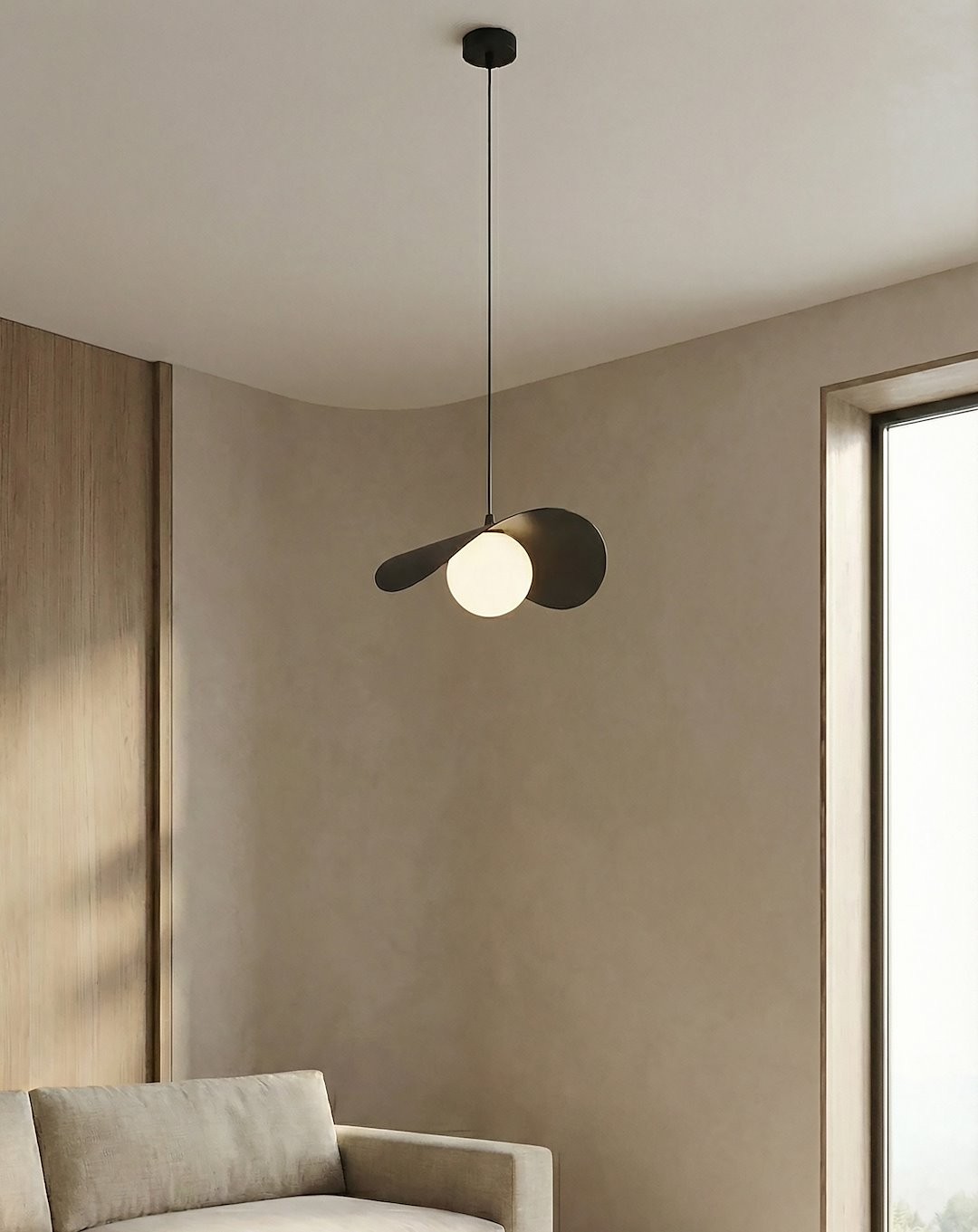 Lampa wisząca Ritual M w kolorze czarnym, z jedną oprawą G9. Posiada okrągły klosz w odcieniu białym oraz dwa asymetryczne, metalowe elementy. Zawieszona na cienkim przewodzie, idealna do nowoczesnych wnętrz.