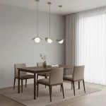 Lampa wisząca Ritual S w kolorze mokka z jednym źródłem światła G9, zawieszona na długim kablu. Produkt umieszczony nad drewnianym stołem w nowoczesnej aranżacji jadalni, w otoczeniu czterech beżowych krzeseł i jasnych zasłon.