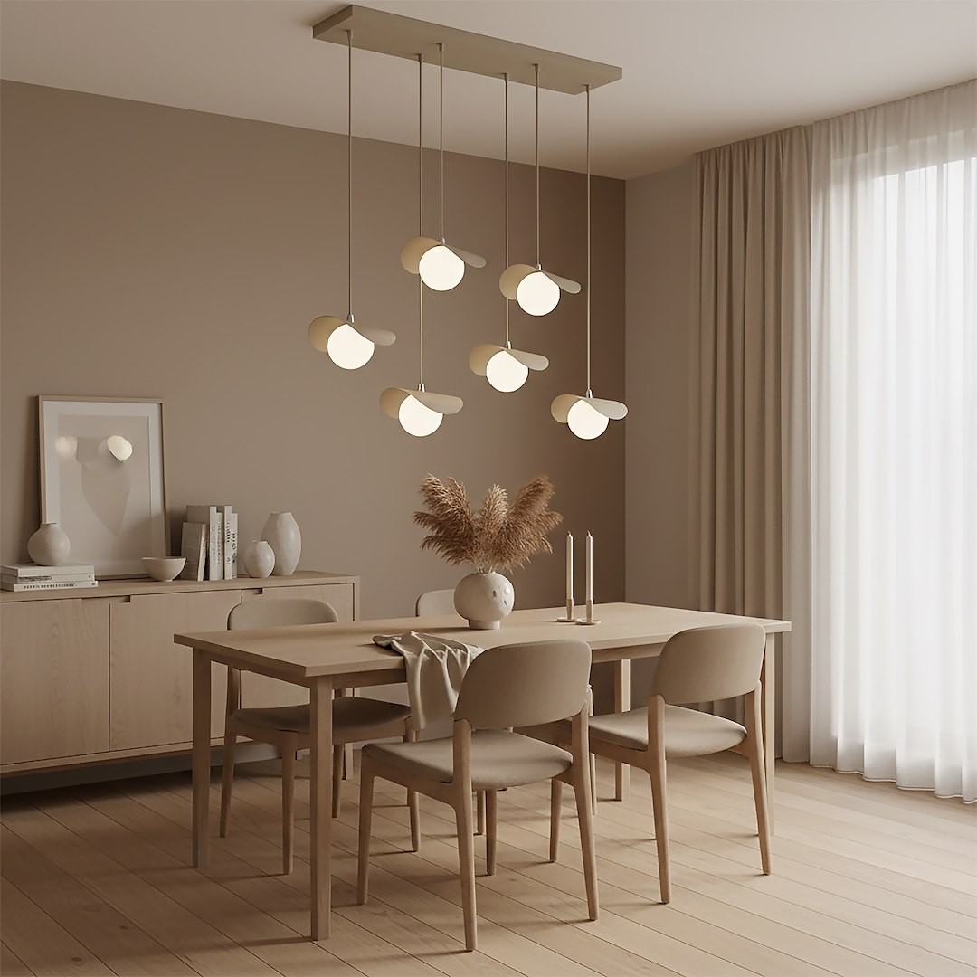 Lampa wisząca Ritual z sześcioma źródłami światła G9 w kolorze mokka, zawieszona na prostokątnej podsufitce. Ułożona nad drewnianym stołem w jasnym wnętrzu, w otoczeniu roślinności i dekoracji.