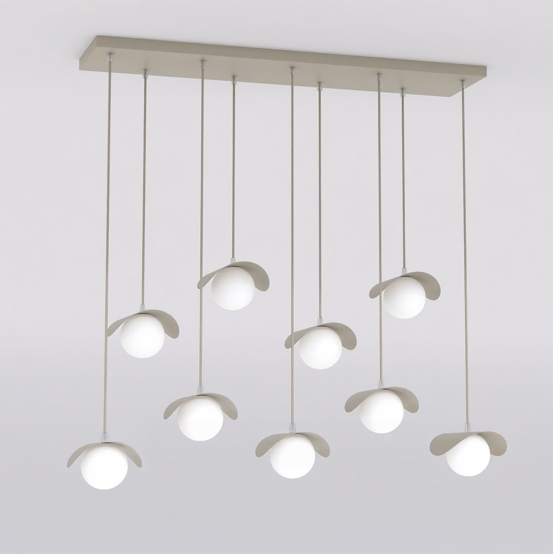 Lampa wisząca Ritual 9xG9 w kolorze mokka z dziewięcioma okrągłymi, białymi kloszami zawieszonymi na cienkich linkach. Ułożona równolegle do sufitu, z delikatnymi, zaokrąglonymi osłonami. Tło jasne, minimalistyczne.