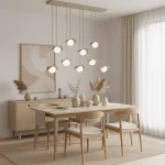 Lampa wisząca Ritual 9xG9 w kolorze mokka, zawieszona na długich linkach, z okrągłymi kloszami. Umieszczona nad drewnianym stołem w jasnym wnętrzu, w otoczeniu minimalistycznych dekoracji i roślin. Tło neutralne, z dużymi oknami.