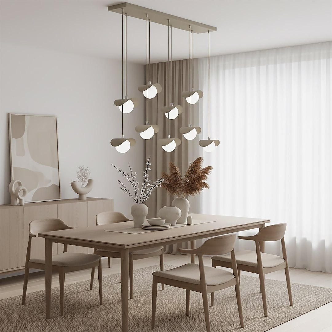 Lampa wisząca Ritual 9xG9 w kolorze mokka z dziewięcioma okrągłymi kloszami, zawieszona na metalowej podstawie. Produkt umieszczony nad drewnianym stołem w jasnym wnętrzu z roślinami i dekoracjami.