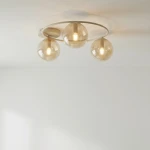 Lampa sufitowa Sopra 3xE14 w kolorze mokka z bursztynowymi kloszami. Ułożona na okrągłej podstawie, z trzema kulistymi źródłami światła. Zdjęcie z góry, na jasnym tle, ukazujące elegancki design lampy.