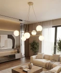 Lampa wisząca Azura 6xE14 w kolorze mokka i białym, z sześcioma okrągłymi kloszami z mlecznego szkła, zawieszona na złotym stelażu. Ujęcie frontalne, w nowoczesnym wnętrzu z jasnymi zasłonami i drewnianą podłogą.
