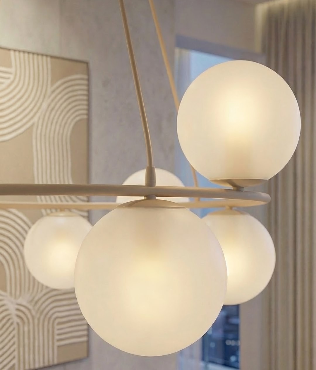 Lampa wisząca Azura w kolorze mokka i białym, z ośmioma kulistymi kloszami, wykonana z matowego szkła. Produkt zawieszony na cienkim stelażu, widok zbliżony, pokazujący detale konstrukcji i rozproszone światło.