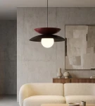Lampa wisząca Nagoya 1xG9 w kolorze czarnym i burgundowym, z okrągłym kloszem, zawieszona na cienkim przewodzie. Widok z dołu, w nowoczesnym wnętrzu z betonową ścianą i jasnym meblem.