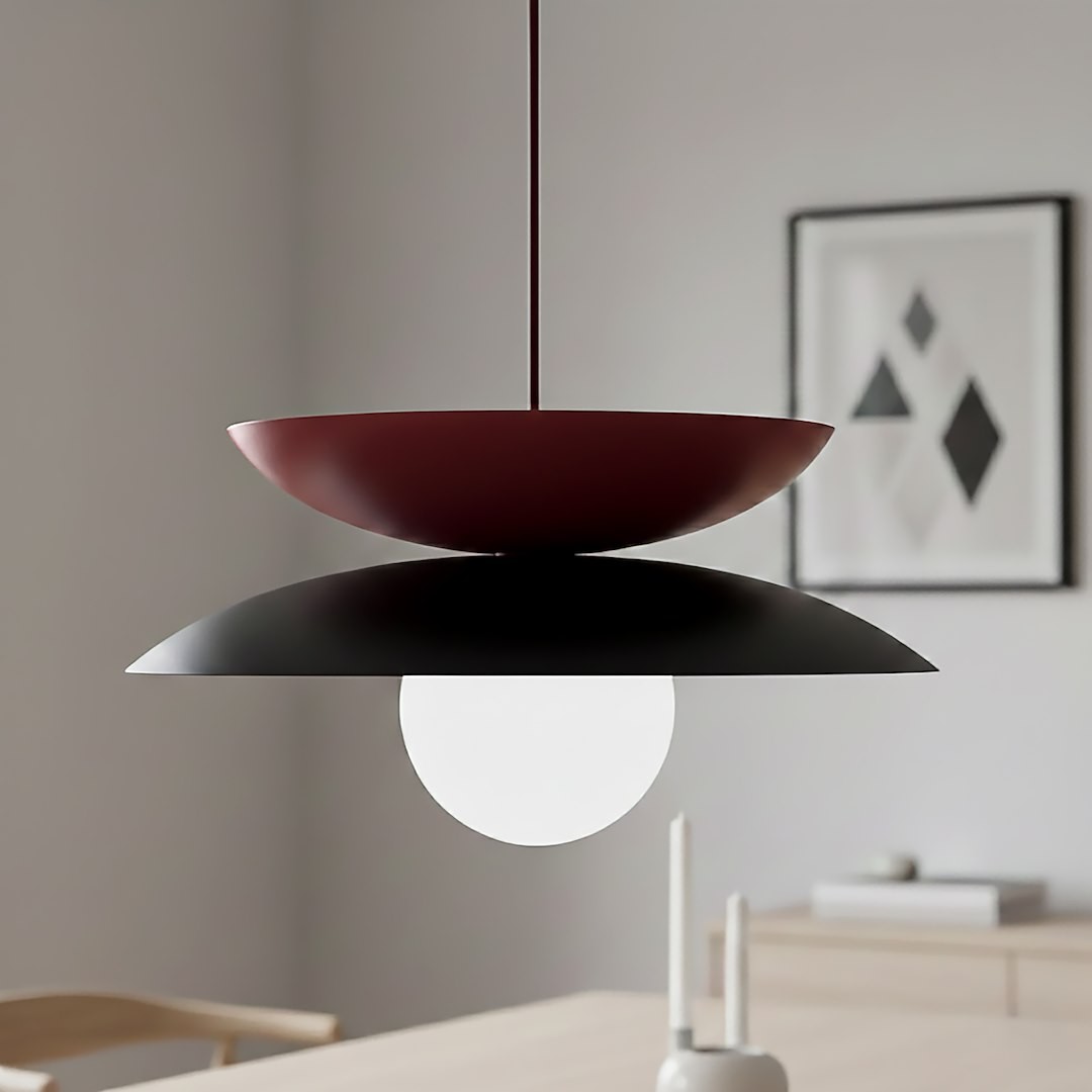 Lampa wisząca Nagoya 1xG9 w kolorze czarnym i burgundowym, z okrągłym, białym kloszem. Ujęcie z dołu, pokazujące dwa nachodzące na siebie talerze. Elementy metalowe i szklane, zawieszona w minimalistycznym wnętrzu.