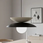 Lampa wisząca Nagoya 1xG9 w kolorze czarnym i mokka, z dwoma talerzami w różnych kolorach i okrągłą, białą żarówką. Zawieszona na cienkim przewodzie, w minimalistycznym wnętrzu.