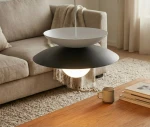 Lampa wisząca Nagoya z jedną oprawą G9, w kolorze czarnym i białym. Posiada okrągły, matowy klosz w dolnej części i gładką, białą podstawę. Wisi nad drewnianym stolikiem w jasnym wnętrzu z sofą w tle.