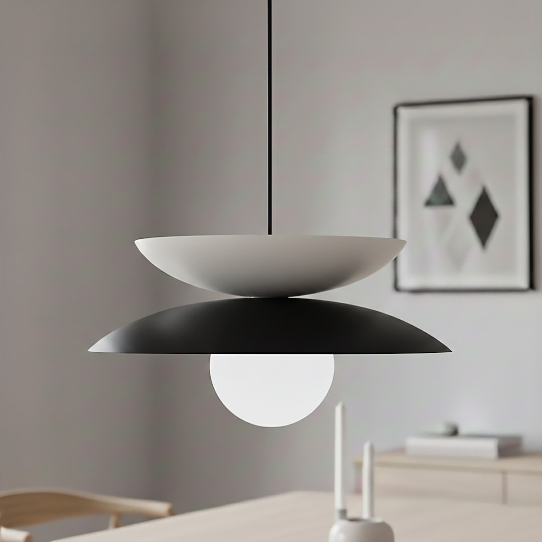 Lampa wisząca Nagoya 1xG9 w kolorze czarnym i białym, z okrągłym źródłem światła, zawieszona na cienkim przewodzie. Górna część ma kształt białej miski, dolna część jest czarna, zapewniając nowoczesny wygląd.