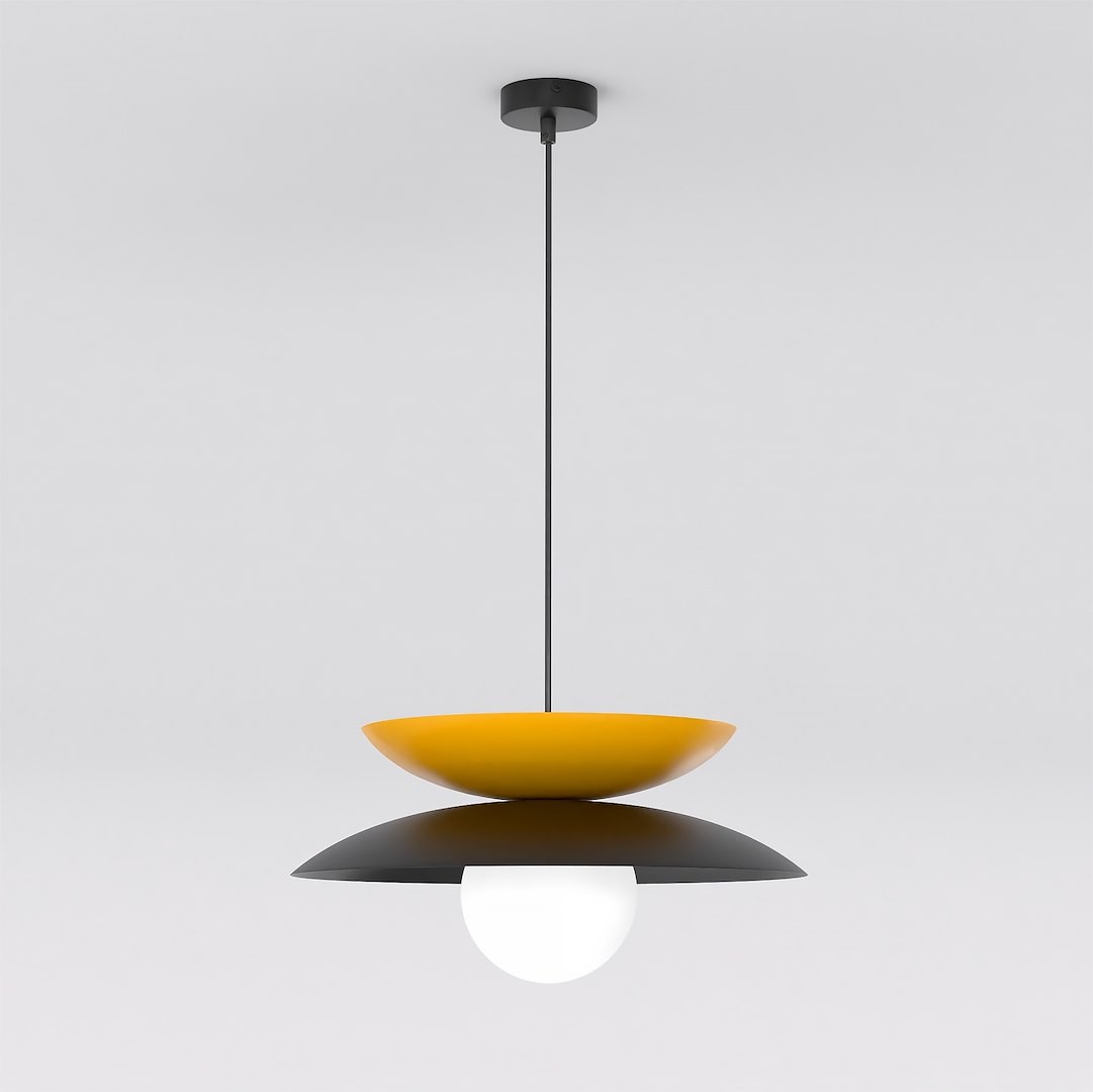 Lampa wisząca Nagoya 1xG9 w kolorze czarnym i pomarańczowym, z okrągłym, białym kloszem. Zawieszona na cienkim, czarnym kablu, z górną pomarańczową misą i dolną czarną osłoną. Ujęcie frontalne, na jednolitym tle.